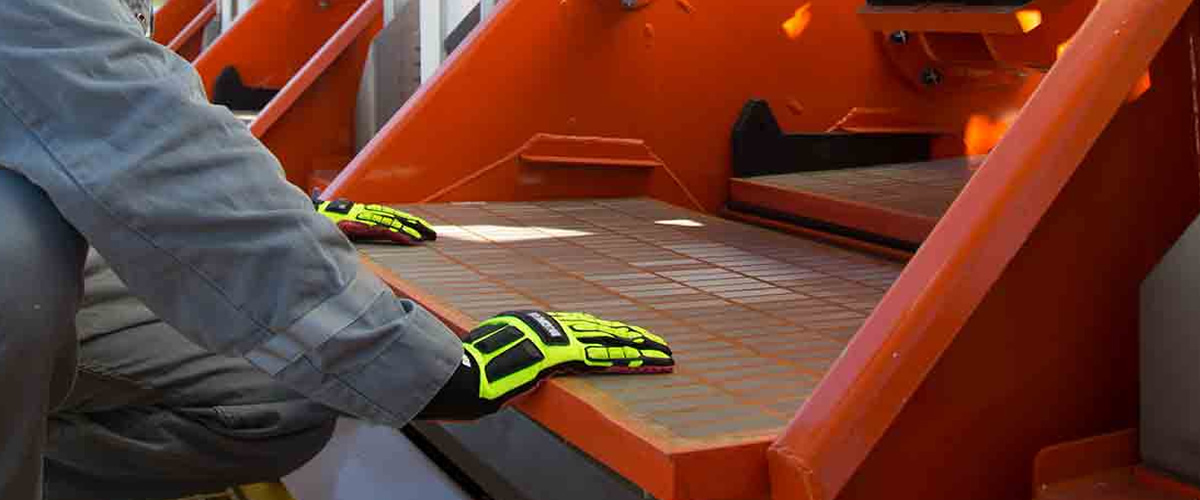 Technician inspecting a shaker screen on a shale shaker